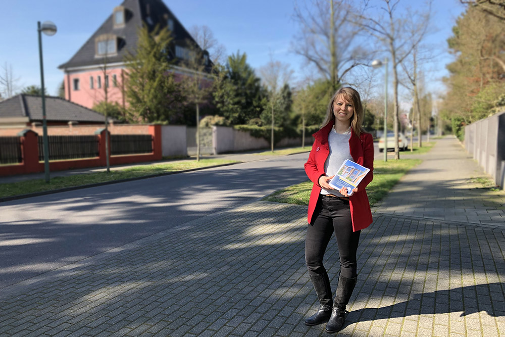 Maklerin verteilt Flyer in der Gartenstadt in Meerbusch für eine Villa in Düsseldorf-Ludenberg/Hubbelrath